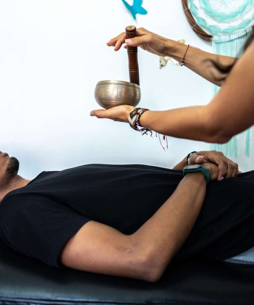 Therapist playing rin gong while performing music therapy at spa